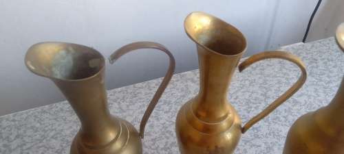 A Collection Of Brass Jugs With Handles