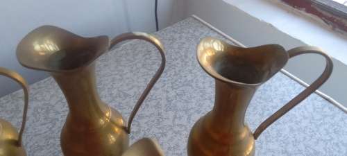 A Collection Of Brass Jugs With Handles