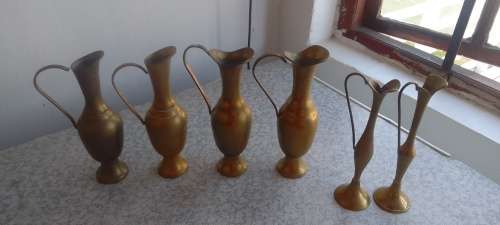 A Collection Of Brass Jugs With Handles
