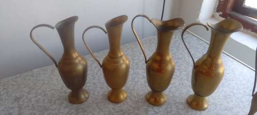 A Collection Of Brass Jugs With Handles