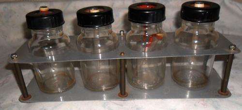 SET OF OLD MEDICAL JARS IN A HOLDER