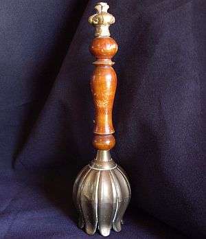 A vintage Indian wood and brass bell