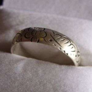 A STERLING SILVER BAND WITH ENGRAVED ABSTRACT DECORATION