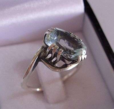 AN OLD LOOKING STERLING SILVER RING SET WITH A LARGE FACETED BLUE STONE