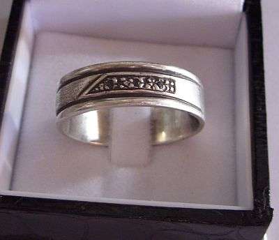 A LARGE STERLING SILVER BAND WITH 3 MINI DIAMONDS