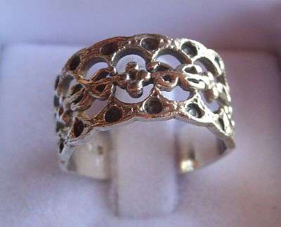 A WIDE STERLING SILVER RING WITH UNUSUAL PIERCED DECORATION