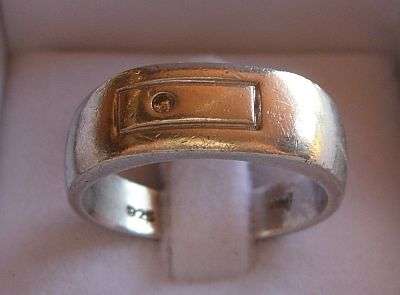 A SOLID STERLING SILVER GENTS AND WITH TINY STONE - POSSIBLE DIAMOND