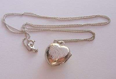 A STERLING SILVER NECKLACE WITH AN ENGRAVED STERLING SILVER HEART LOCKET