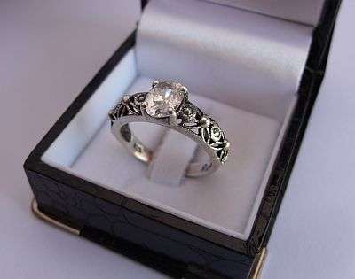 A STYLISH & SOLID STERLING SILVER RING SET WITH A SINGLE FACETED CZ STONE