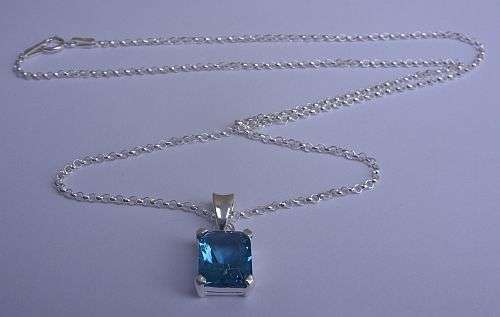 A STERLING SILVER NECKLACE WITH A GORGEOUS FACETED BLUE CZ SET PENDANT