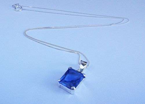 A LOVELY STERLING SILVER NECKLACE WITH AN INCREDIBLE FACETED BLUE STONE SET PENDANT ...ALL SILVER !!