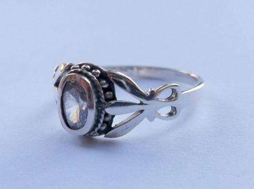 A MARVELOUSLY DETAILED STERLING SILVER RING SET WITH A FACETED CLEAR STONE..CLASSIC LOOK..LAST ONE !