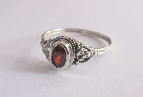 A CLASSY STERLING SILVER RING WITH FLORAL DESIGN AND FACETED RED STONE !! PRAGTIG !!