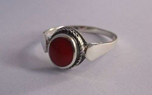 AN EYE CATCHING STERLING SILVER RING SET WITH A CORAL LOOK CENTER ....GOOD QUALITY !!!