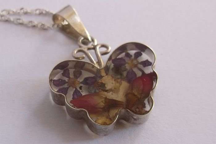 A STERLING SILVER NECKLACE WITH HEART PENDANT...DRY FLOWERS IN A PERSPEX HEART...SILVER FRAME