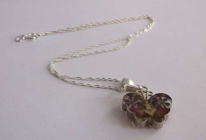 A STERLING SILVER NECKLACE WITH HEART PENDANT...DRY FLOWERS IN A PERSPEX HEART...SILVER FRAME