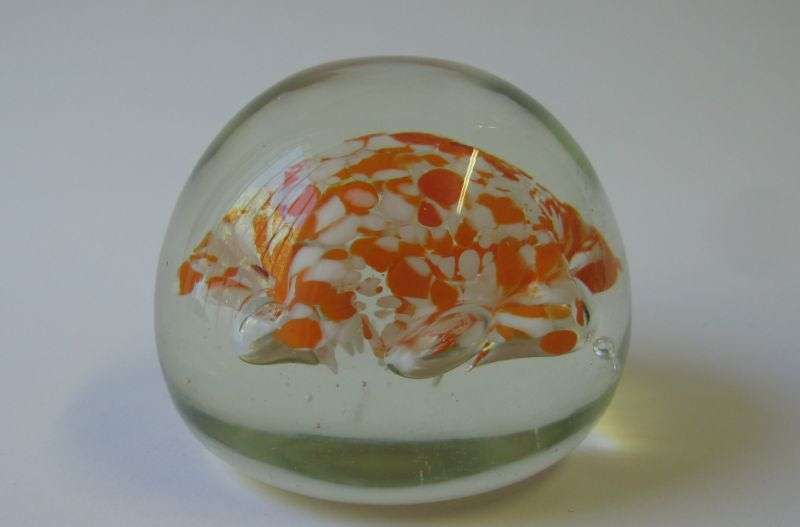 A COOL LOOKING VINTAGE SOLID GLASS PAPERWEIGHT WITH WHITE AND ORANGE SPECKLES DETAIL...NICE !!