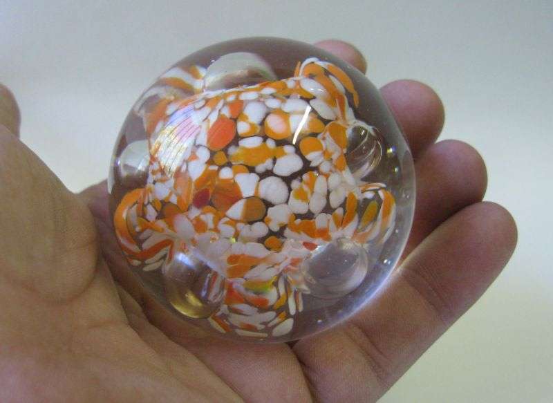 A COOL LOOKING VINTAGE SOLID GLASS PAPERWEIGHT WITH WHITE AND ORANGE SPECKLES DETAIL...NICE !!