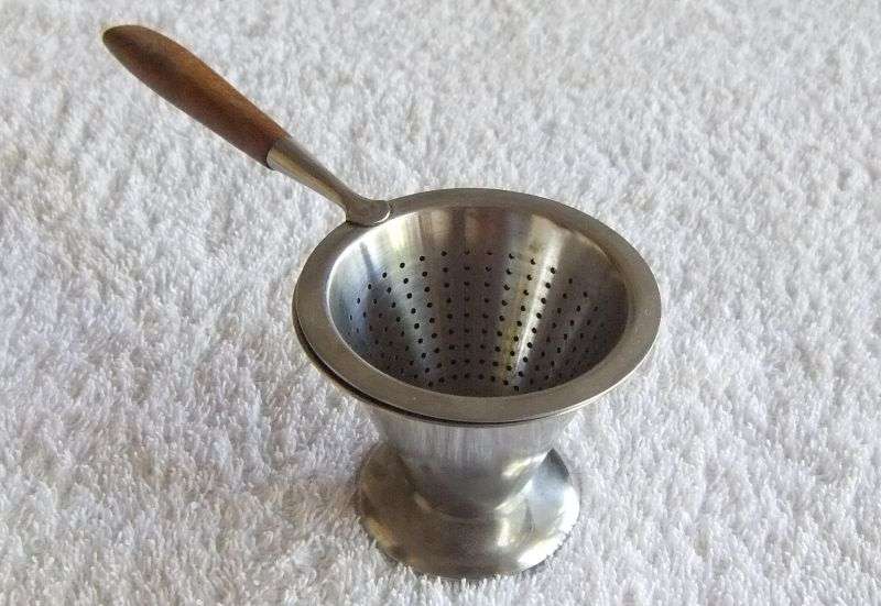 A VINTAGE DESIGNER TEA STRAINER BY RIDDERVOLD OF NORWAY IN EXCELLENT CONDITION ...STAINLESS STEEL !!