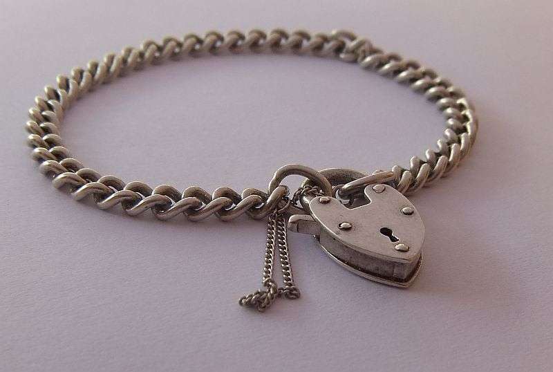 A STUNNING AND STRONG QUALITY VINTAGE SOLID STERLING SILVER CHARM STARTER BRACELET WITH HEART CLASP