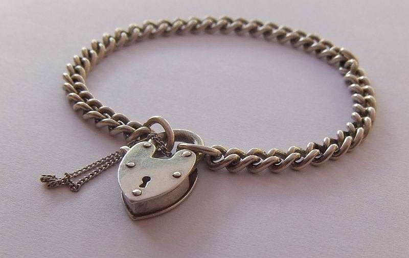 A STUNNING AND STRONG QUALITY VINTAGE SOLID STERLING SILVER CHARM STARTER BRACELET WITH HEART CLASP