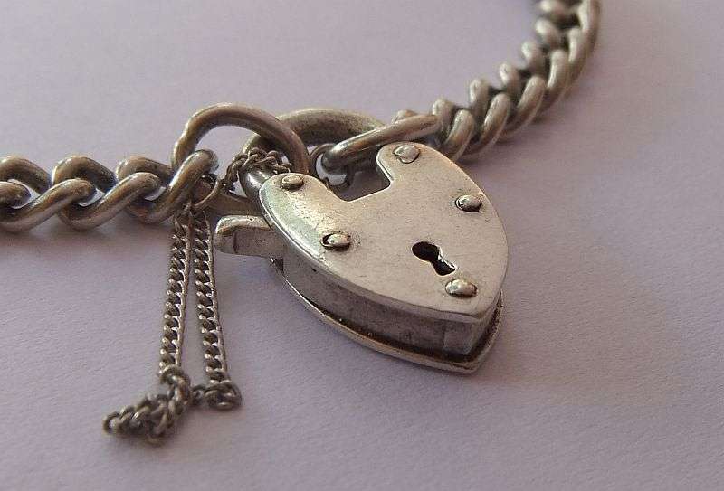 A STUNNING AND STRONG QUALITY VINTAGE SOLID STERLING SILVER CHARM STARTER BRACELET WITH HEART CLASP