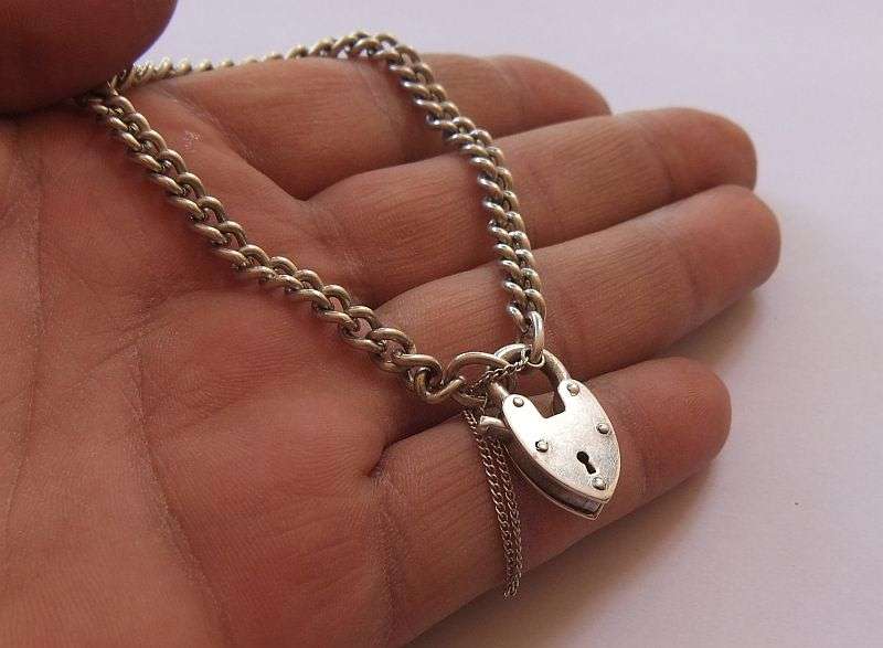A STUNNING AND STRONG QUALITY VINTAGE SOLID STERLING SILVER CHARM STARTER BRACELET WITH HEART CLASP