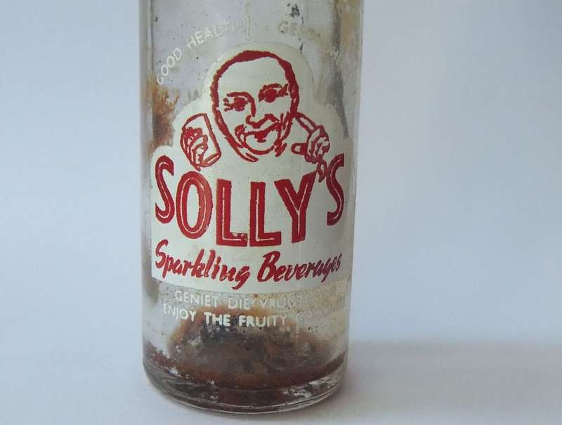 MADE IN KRUGERSDORP !! BILINGUAL ADVERTISING !!  A VINTAGE MINIATURE "SOLLY`S" COOLDRINK BOTTLE