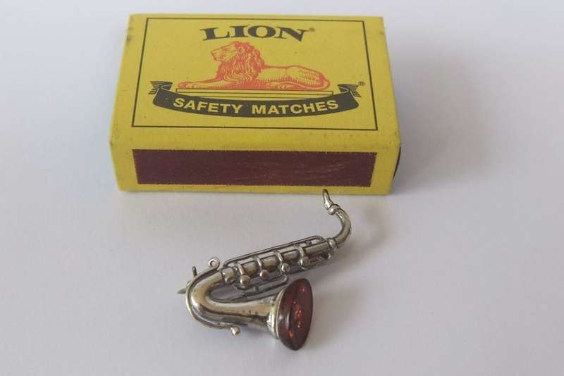 A GORGEOUS INTERESTING WELL MADE VINTAGE STERLING SILVER AND GENUINE AMBER DESIGNER SAXOPHONE BROOCH