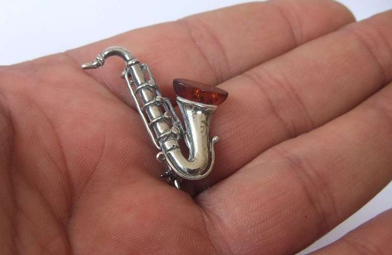 A GORGEOUS INTERESTING WELL MADE VINTAGE STERLING SILVER AND GENUINE AMBER DESIGNER SAXOPHONE BROOCH