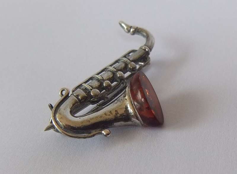 A GORGEOUS INTERESTING WELL MADE VINTAGE STERLING SILVER AND GENUINE AMBER DESIGNER SAXOPHONE BROOCH