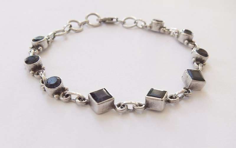 AN EYE CATCHING SOLID STERLING SILVER BRACELET SET WITH FACETED BLUEISH PURPLISH STONES !! QUALITY !