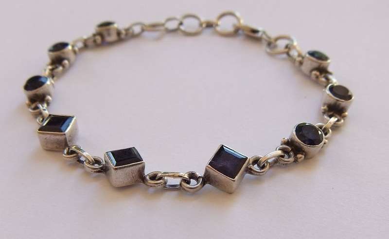 AN EYE CATCHING SOLID STERLING SILVER BRACELET SET WITH FACETED BLUEISH PURPLISH STONES !! QUALITY !