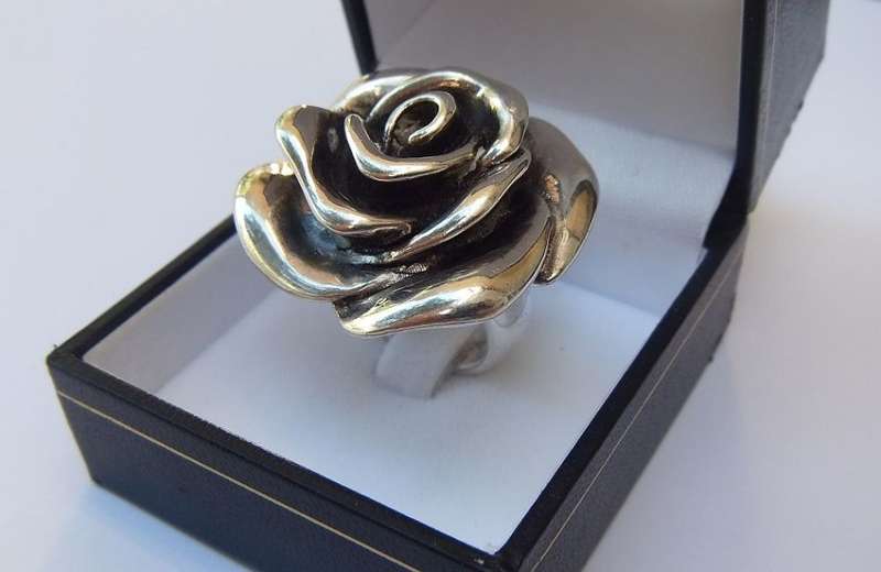 A STERLING SILVER LARGE ROSE FORM RING - STAMPED AND TESTED