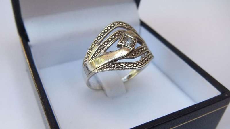 A SOLID STERLING SILVER RING SET WITH A FACETED CZ STONE - FULLY TESTED