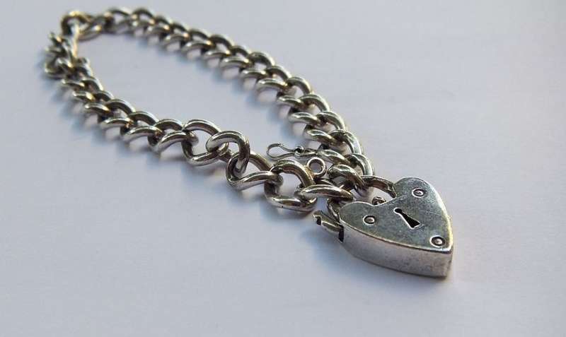 A VINTAGE SOLID STERLING SILVER STARTER CHARM BRACELET WITH HEART CLASP - STAMPED AND TESTED