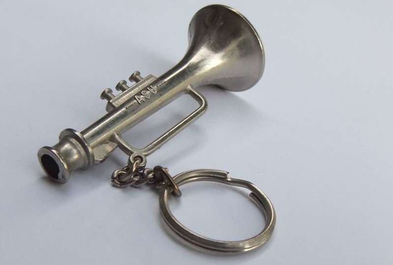 A VINTAGE SOLID METAL TRUMPET MOTIF KEYRING