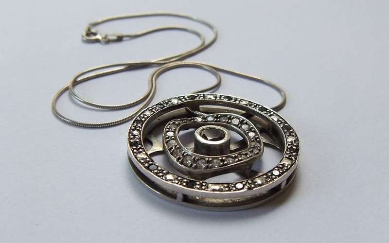 A STYLISH STERLING SILVER "WHEEL" PENDANT SET WITH VARIOUS STONES PLUS A STERLING SILVER NECKLACE !!
