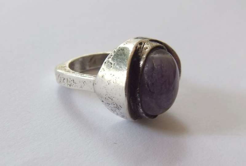 A RARE VINTAGE SOLID STERLING SILVER RING SET WITH A CABOCHON AMETHYST BY DANISH DESIGNER N.E FROM