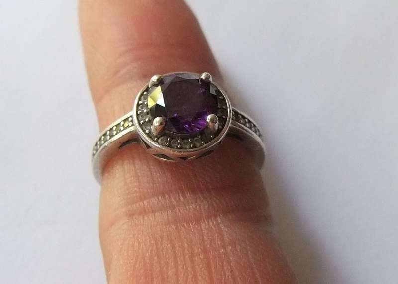 A CLASSY SOLID STERLING SILVER RING SET WITH A FACETED PURPLE STONE AND SMALL CLEAR STONES !! TESTED