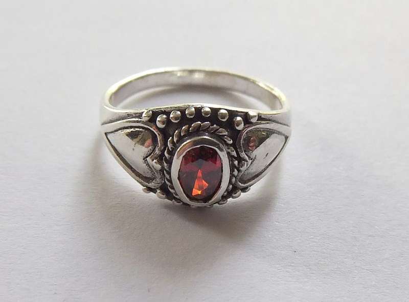 A STYLISH SOLID STERLING SILVER RING SET WITH A FACETED RED STONE !! STAMPED AND TESTED !!
