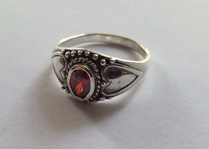 A STYLISH SOLID STERLING SILVER RING SET WITH A FACETED RED STONE !! STAMPED AND TESTED !!