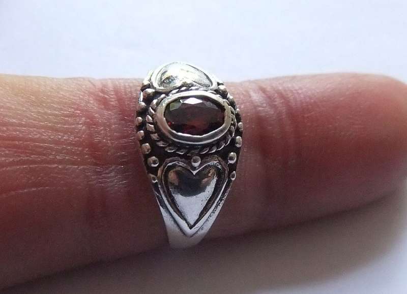A STYLISH SOLID STERLING SILVER RING SET WITH A FACETED RED STONE !! STAMPED AND TESTED !!