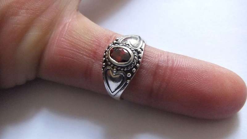 A STYLISH SOLID STERLING SILVER RING SET WITH A FACETED RED STONE !! STAMPED AND TESTED !!