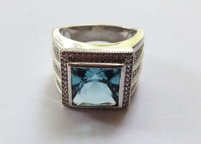 A SUPERIOR QUALITY SOLID STERLING SILVER RING SET WITH A BEAUTIFULLY FACETED BLUE STONE AND MORE !!
