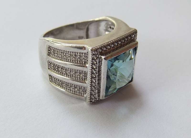 A SUPERIOR QUALITY SOLID STERLING SILVER RING SET WITH A BEAUTIFULLY FACETED BLUE STONE AND MORE !!