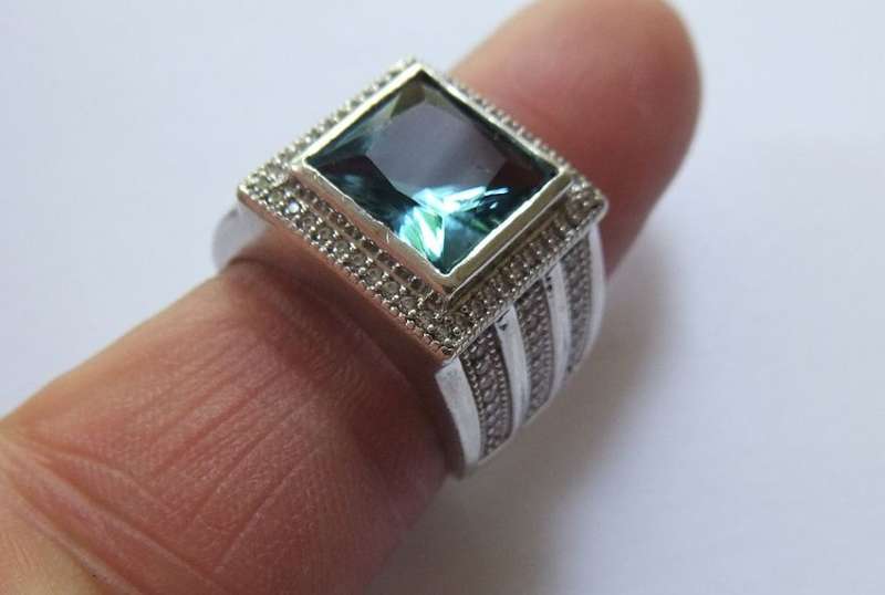 A SUPERIOR QUALITY SOLID STERLING SILVER RING SET WITH A BEAUTIFULLY FACETED BLUE STONE AND MORE !!