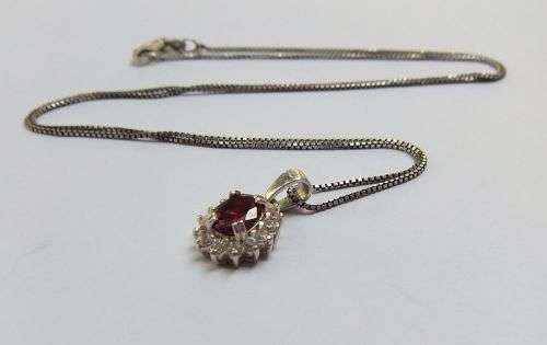A CHARMING SOLID STERLING SILVER PENDANT SET WITH A FACETED RED STONE PLUS STERLING SILVER NECKLACE