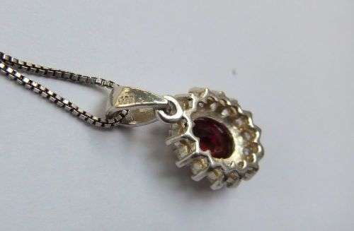 A CHARMING SOLID STERLING SILVER PENDANT SET WITH A FACETED RED STONE PLUS STERLING SILVER NECKLACE