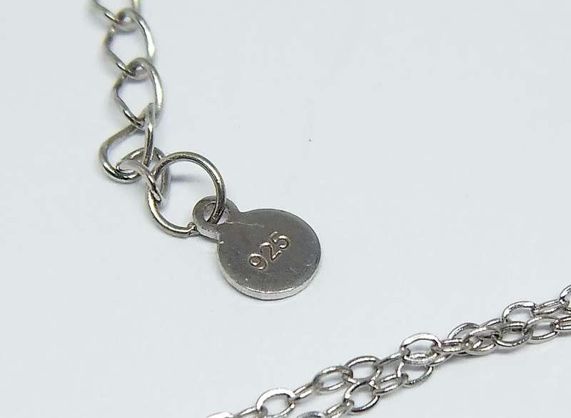 A genuine sterling silver necklace and heart pendant containing the tree of life with clear insets